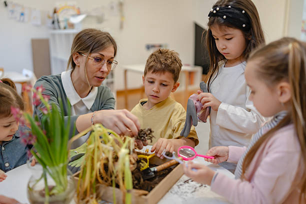 istock Teacher and curious children explore soil and plants in a classroom science activity, encouraging hands-on learning and environmental awareness in a diverse group of students. 2209614888
