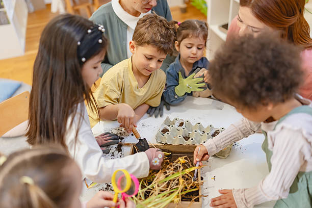 istock Teacher and curious children explore soil and plants in a classroom science activity, encouraging hands-on learning and environmental awareness in a diverse group of students. 2209615738
