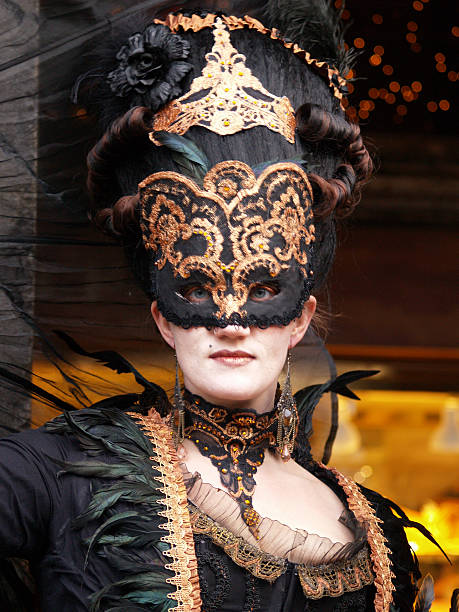 Venice, Italy - February 10, 2024: A couple of tourists wearing costumes at the first day of Venice's Carnival while walking around San Marco square.
