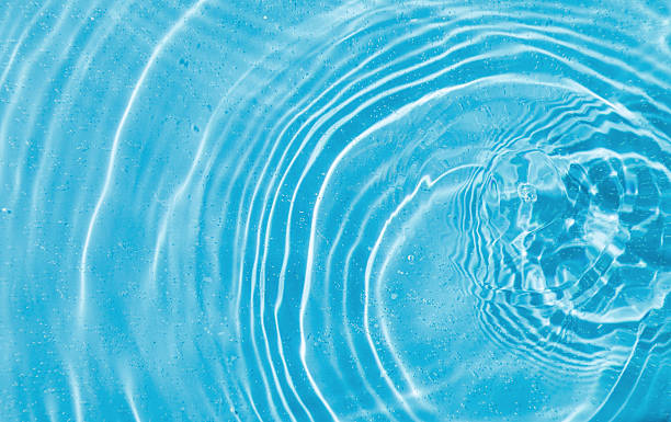 istock drops on water with circles on a blue background 2209621446
