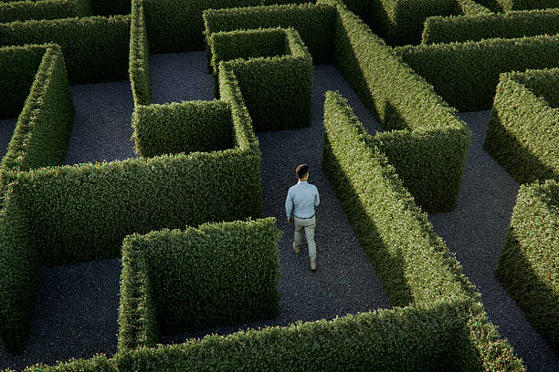 mann läuft im labyrinth - irrgarten stock-fotos und bilder