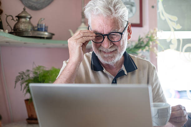 istock White haired senior man sitting indoors using laptop surfing internet, modern bearded senior man addicted enjoying technology and social media 2209625791
