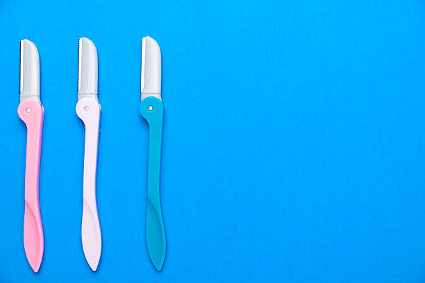 istock women's razors with plastic handles of different colors on a blue background. Space for text. 2209629782