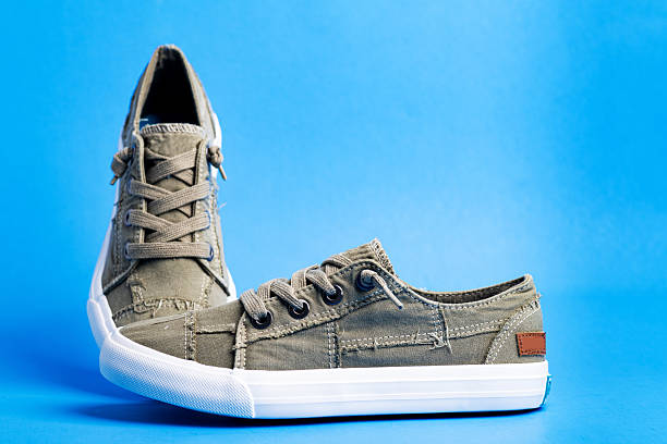 istock Pair of green hipster sneakers on a blue background. Space for text. 2209629853