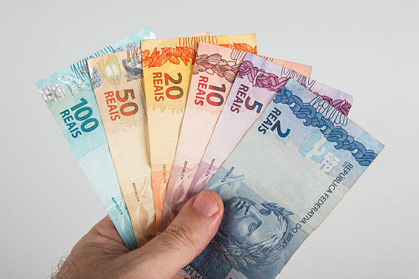 istock Brazilian Money. Brazilian Real notes in hand 2209630911