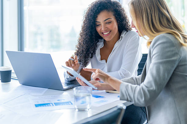 istock Business colleagues having a conversation. They are both young business people casually dressed in a modern office. 2209630975