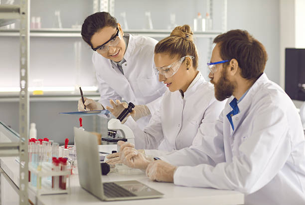 istock Group of young scientists working in a modern pharma or biotech science laboratory 2209634351