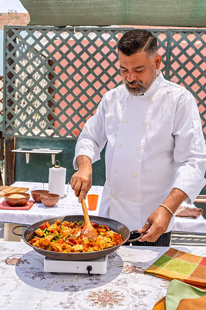 istock Chef preparing paella outdoors on rooftop for family meal 2209634954