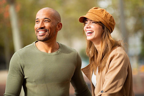 istock cheerful couple standing outdoors and laughing 2209636405