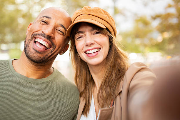 istock smiling couple taking selfie outdoors in park 2209636408