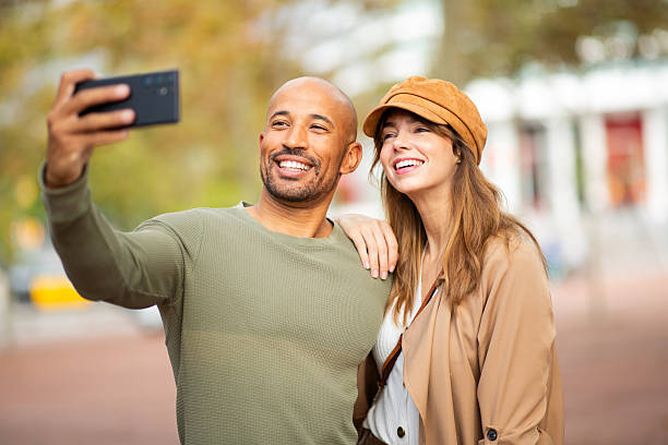 istock smiling man and woman pose for a selfie in park 2209636420