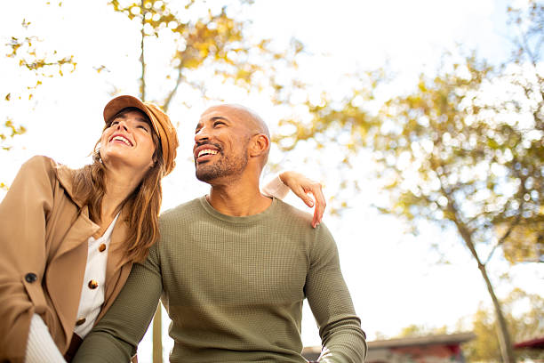istock smiling man and woman looking away at park 2209636426