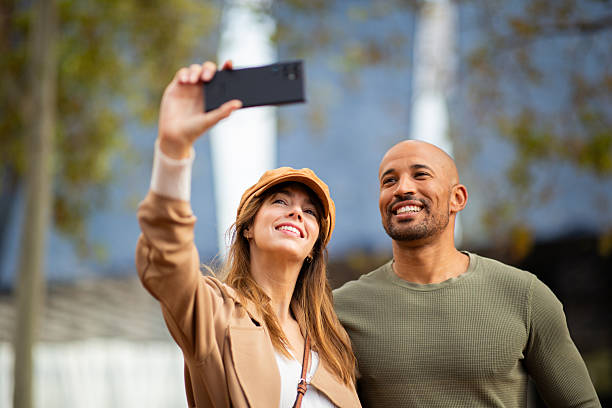 istock smiling couple taking selfie and standing outdoors with mobile phone 2209636440