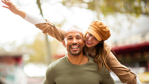 istock man gives her partner a piggyback ride, both laughing and embracing 2209636467