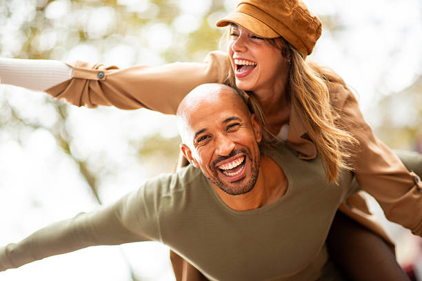 istock stylish couple sharing a fun piggyback ride outdoors with arms outstretched 2209636496