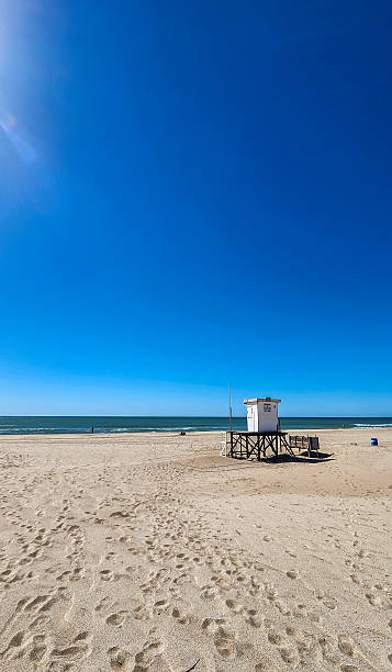 istock Sunny Coastal View with Lifeguard Tower on Sandy Beach 2209637252