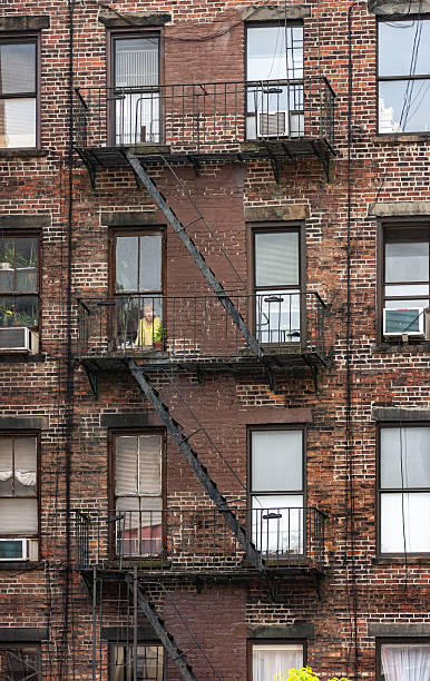 istock Brick Apartment Building With Fire Escapes Visible on the Facade in Urban Setting 2209637979