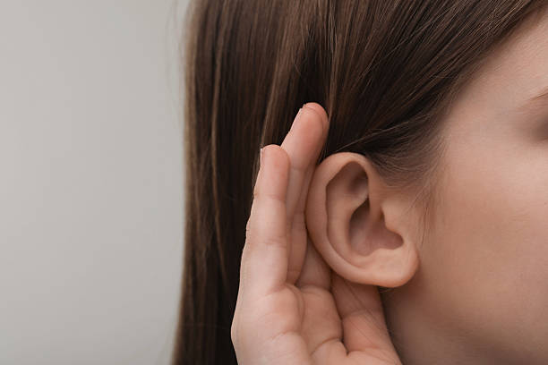 istock Little girl with hearing problem on grey background, closeup. Space for text 2209638842
