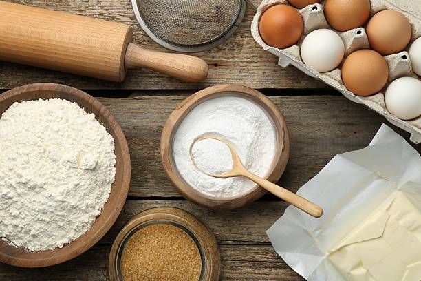 istock Ingredients for making dough, rolling pin and sieve on wooden table, flat lay 2209639627