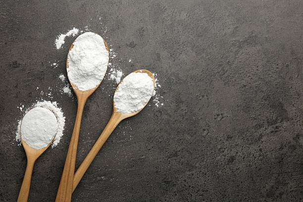 istock Baking powder in spoons on grey textured table, flat lay. Space for text 2209639629