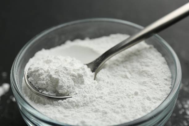 istock Baking powder in bowl and spoon on black table, closeup 2209639660