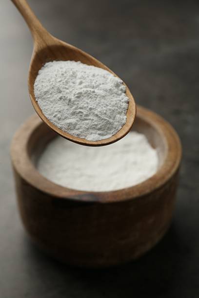 istock Spoon of baking powder over bowl at grey textured table, closeup 2209639675