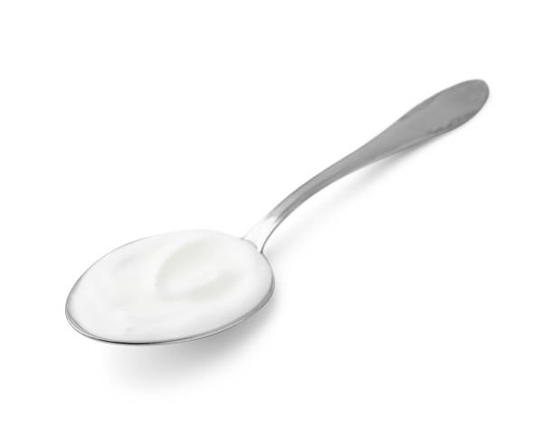 istock Delicious natural yogurt in spoon isolated on white 2209639685