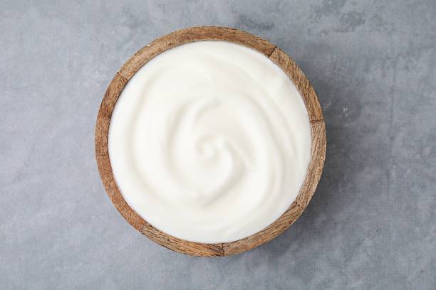 istock Delicious natural yogurt in bowl on grey table, top view 2209639692