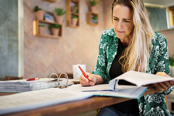 istock Female teacher assessing exam papers at cafe table 2209640278