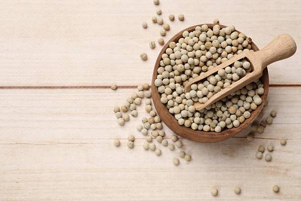 istock Aromatic spice. White peppers and scoop in bowl on wooden table, top view. Space for text 2209640483