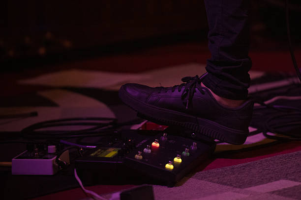 istock Musician's foot pressing a pedalboard during a live stage performance. 2209640897
