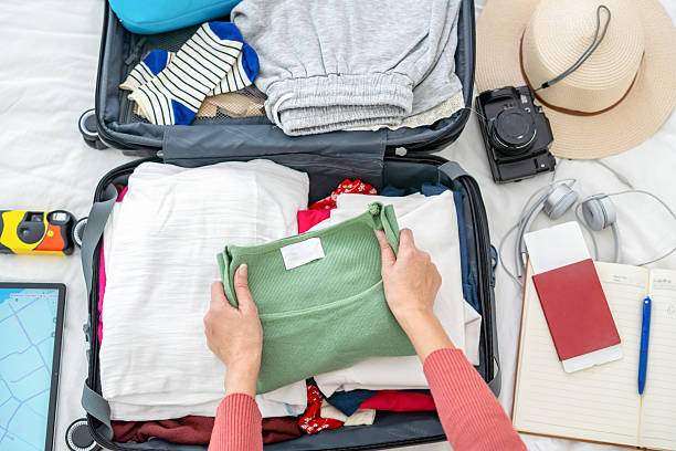 istock woman's hand preparing summer luggage 2209644764