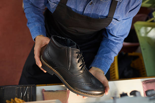 istock Closeup midsection top view shot on luxury leather shoe in shoemaker hand 2209648896