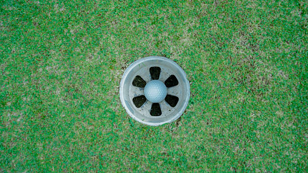 istock Golf balls in hole on the golf course. 2209649194