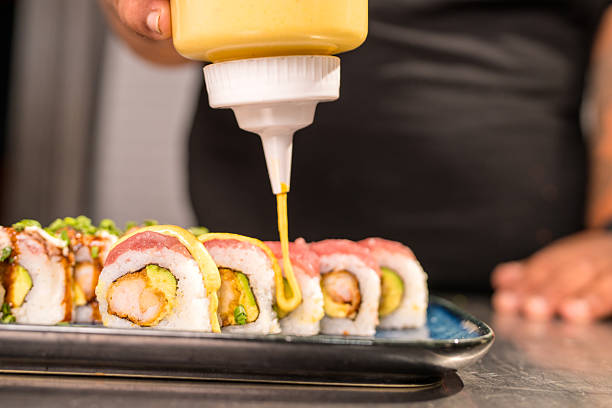 istock Chef pouring sauce on maki sushi in a restaurant 2209650160