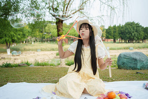 Woman playing with bubble wand in park