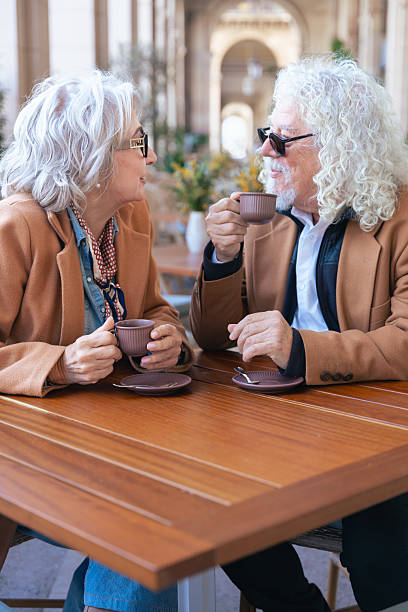 istock Caucasian senior couple talking closely while drinking coffee at outdoor cafe 2209662427