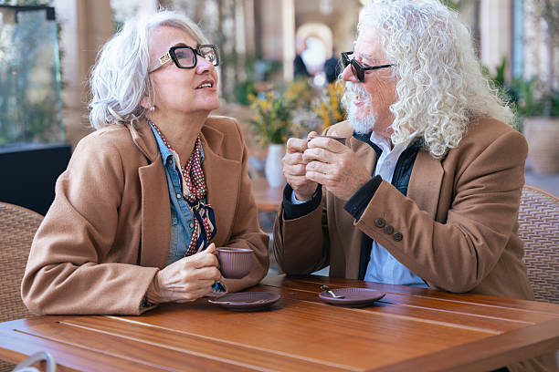 istock Caucasian senior couple talking closely while drinking coffee at outdoor cafe 2209663361