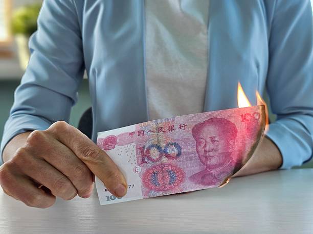 istock Person burns a 100 yuan banknote to express frustration in a creative protest concept 2209668153