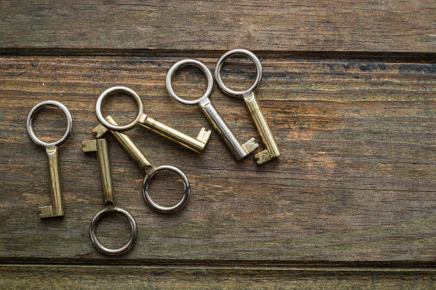 Six golden keys on a wooden background. Copy space