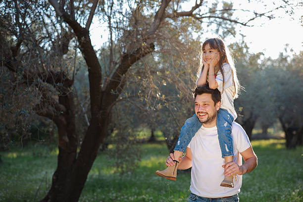 Concept of father's day! Happy family dad and child daughter back in nature. Blooming trees
