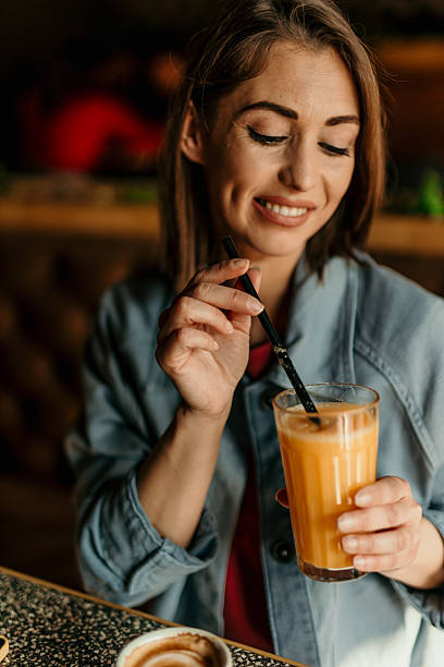 istock Young Woman Enjoying a Refreshing Beverage at a Cafe 2209673755