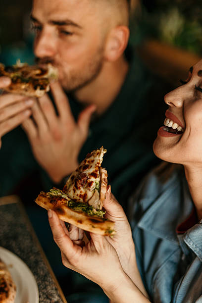 istock Couple enjoying delicious pizza slices at restaurant 2209673866