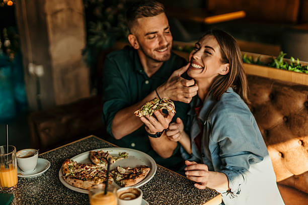 istock Couple eating pizza and having fun at the restaurant 2209673903