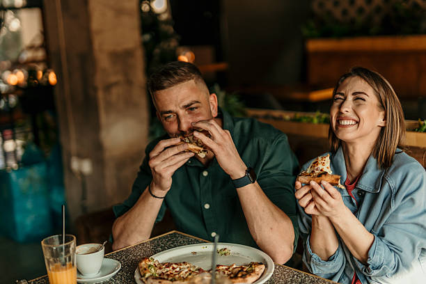 istock Couple enjoying pizza together at restaurant 2209673962
