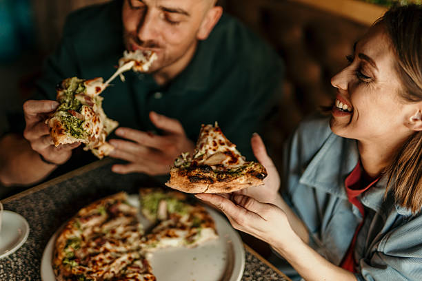 istock Couple enjoying delicious pizza at restaurant 2209673963