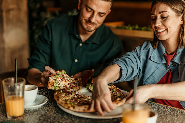 istock Couple enjoying pizza and drinks at a restaurant 2209674003