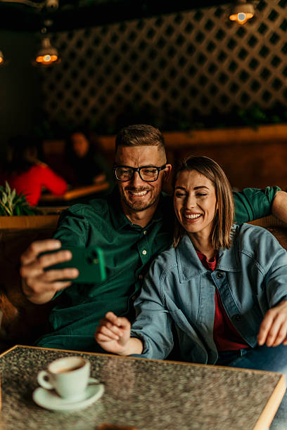 istock Happy couple taking selfie while having coffee in cafe 2209674020