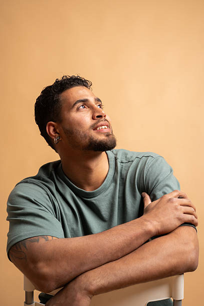istock Colombian man sitting and looking up with hope 2209674934