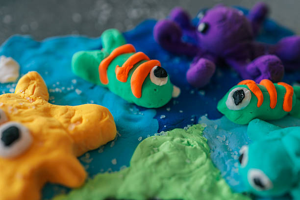 istock Colorful handmade sea creatures made from modeling clay, including fish, starfish, turtle, and octopus on a blue ocean-themed background with salt details 2209677460